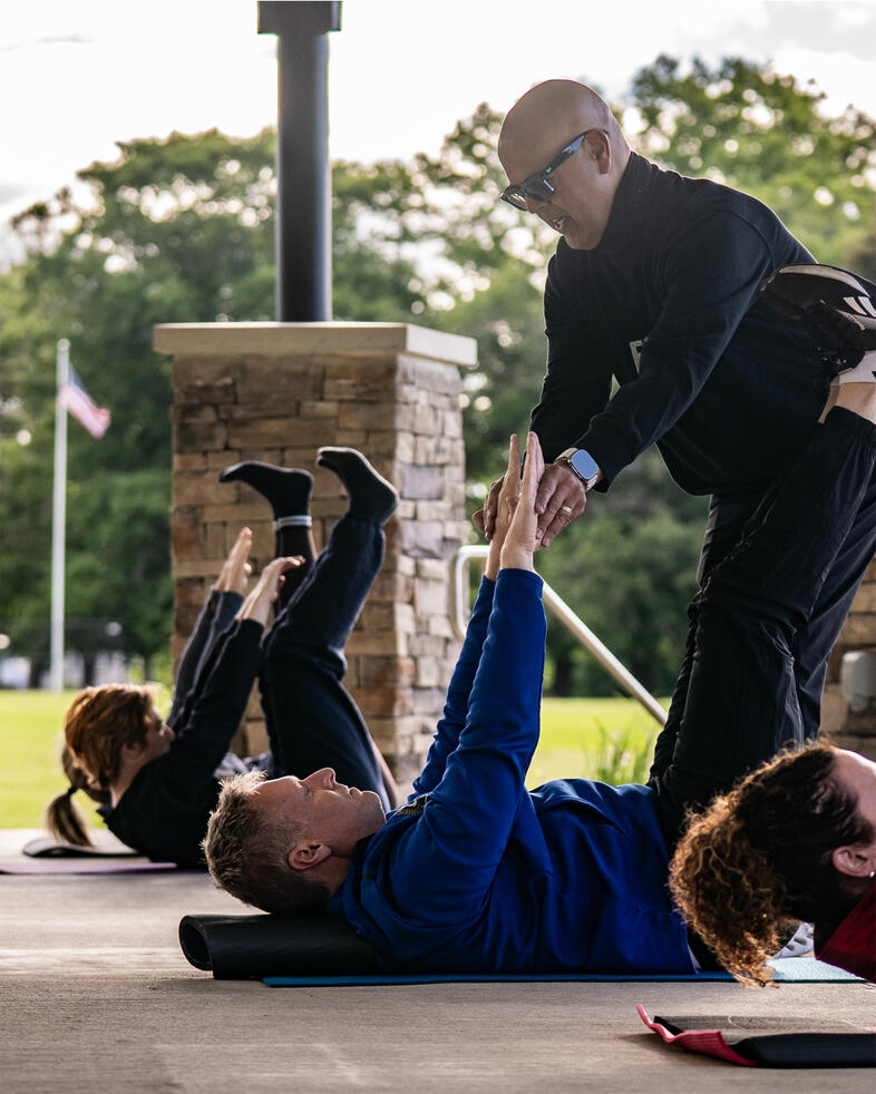1-on-1 Instructor guiding a participant during a mat Pilates movement.