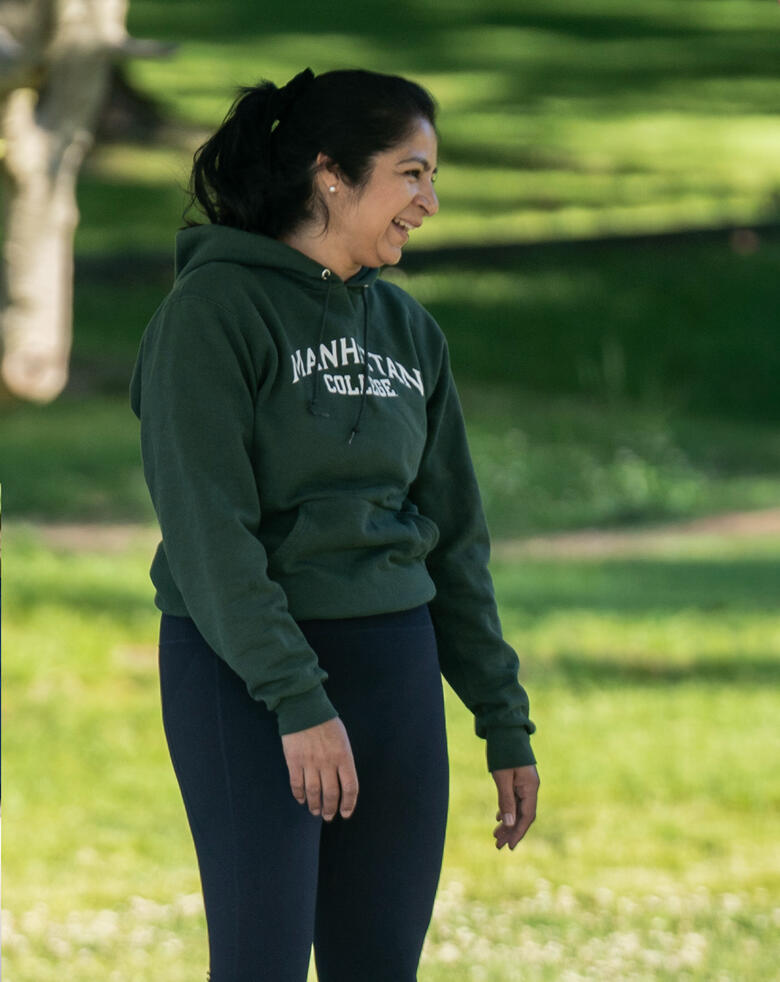 Community & Connection Participant smiling during an outdoor morning Pilates class at Brookdale Park.