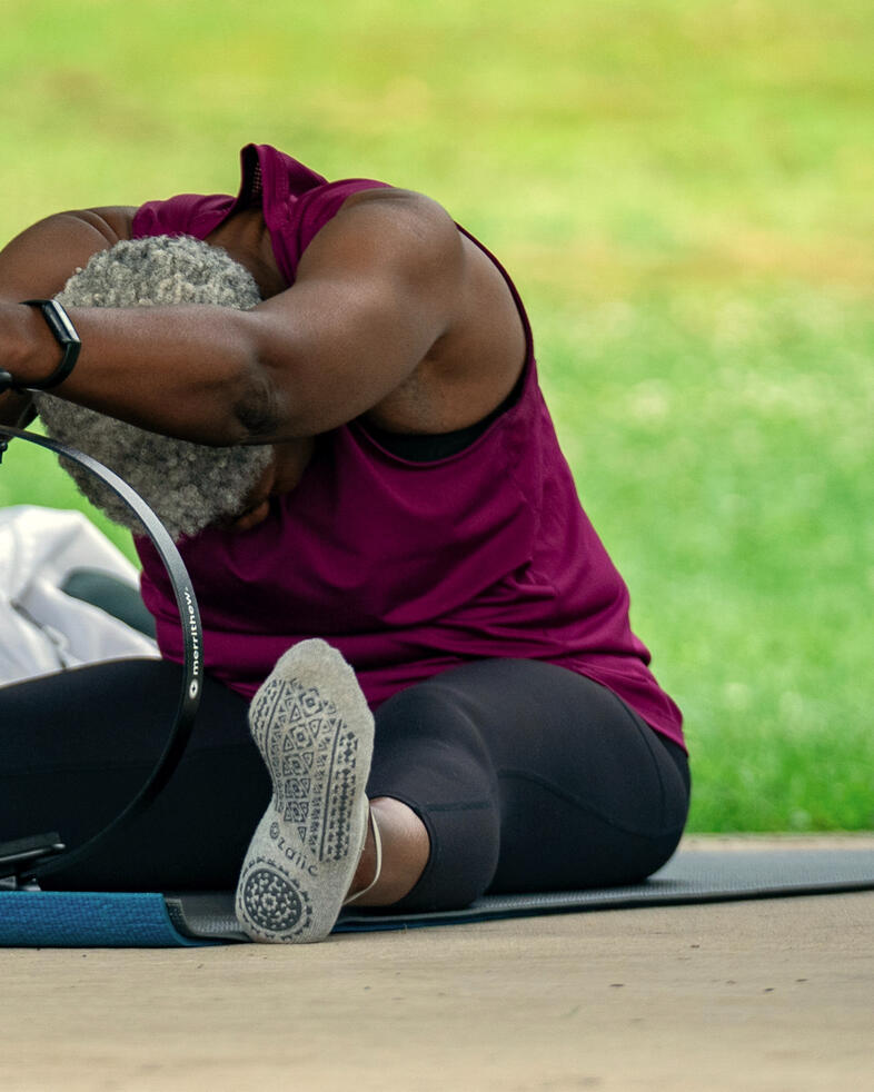 Participant performing cat-cow exercise using ring.