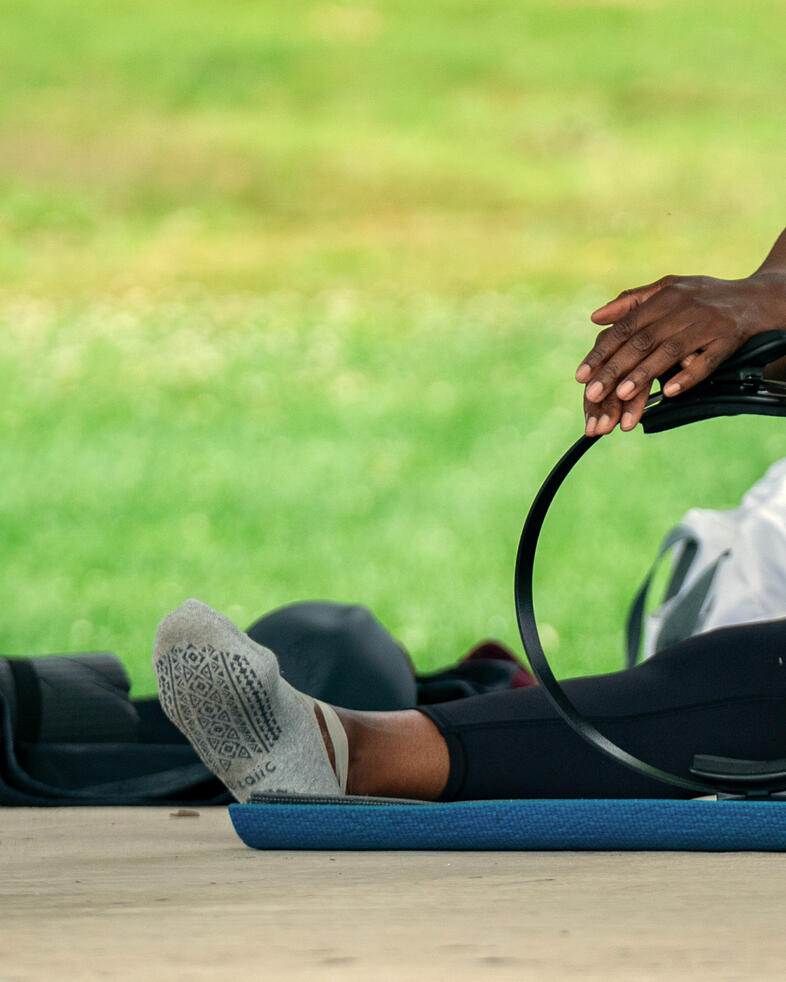Participant performing cat-cow exercise using ring.