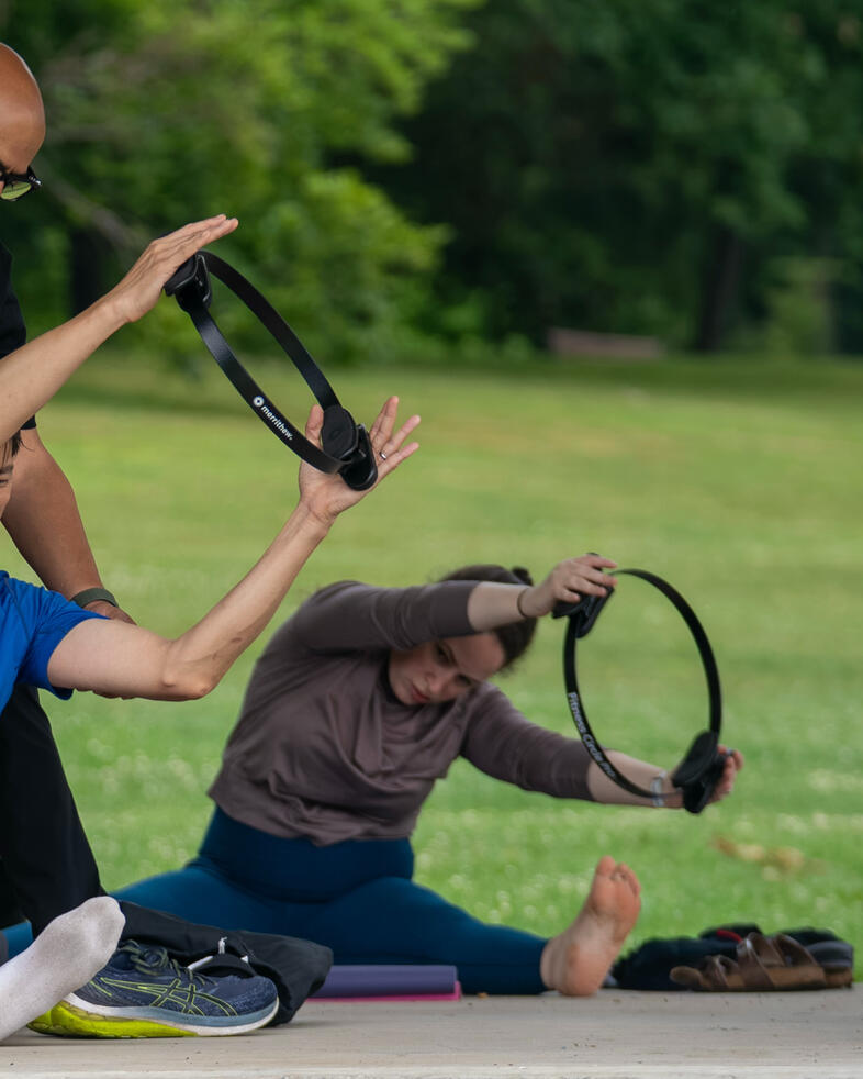 Ring Work Participants practicing Pilates Magic Circle exercises during an outdoor class.