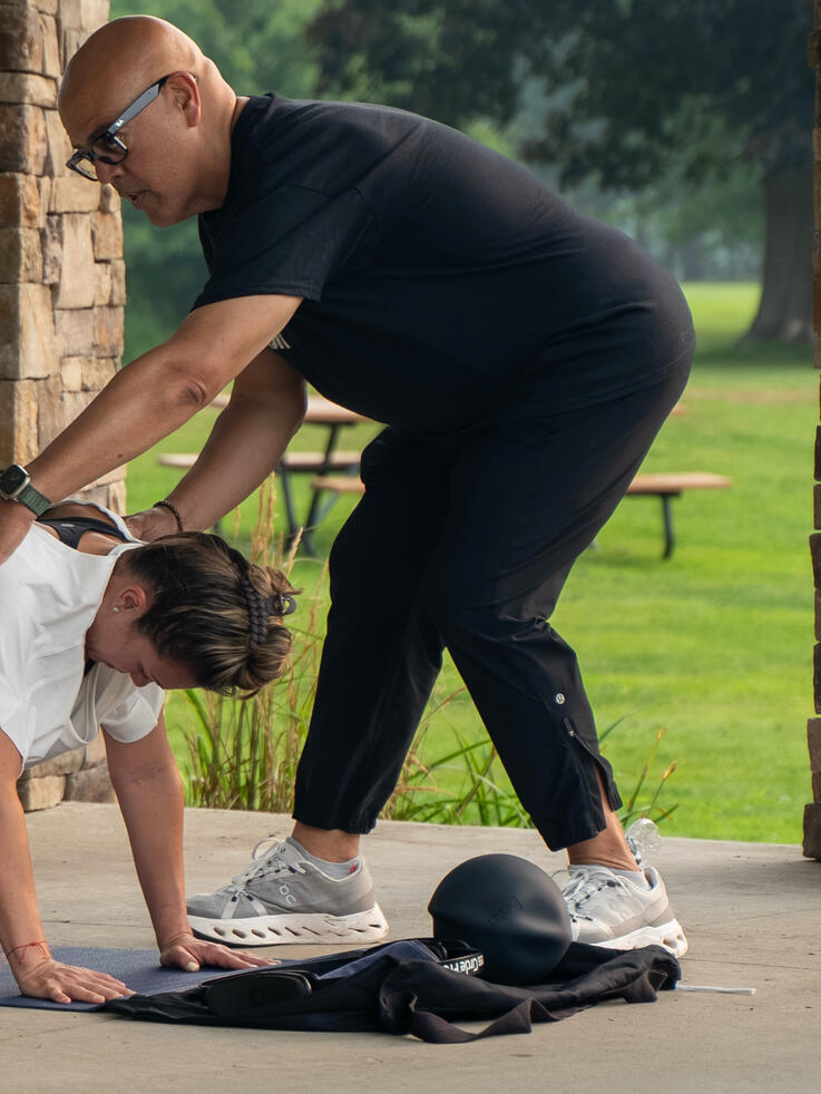 Instructor guiding participants planking form.