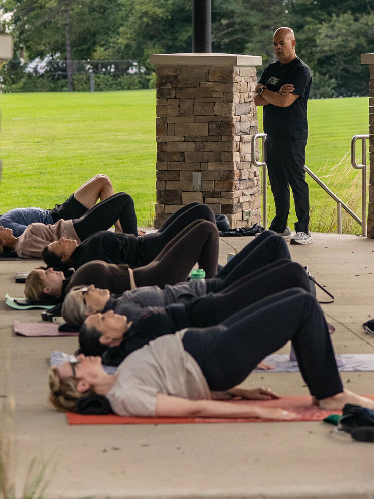 Mat class participants working on glutes, hamstrings and lumbo-pelvic mobility.